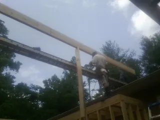 Carpenter setting a ridge beam over a new addition frame — Ice Dam Removal by Roofing Brothers in Buffalo